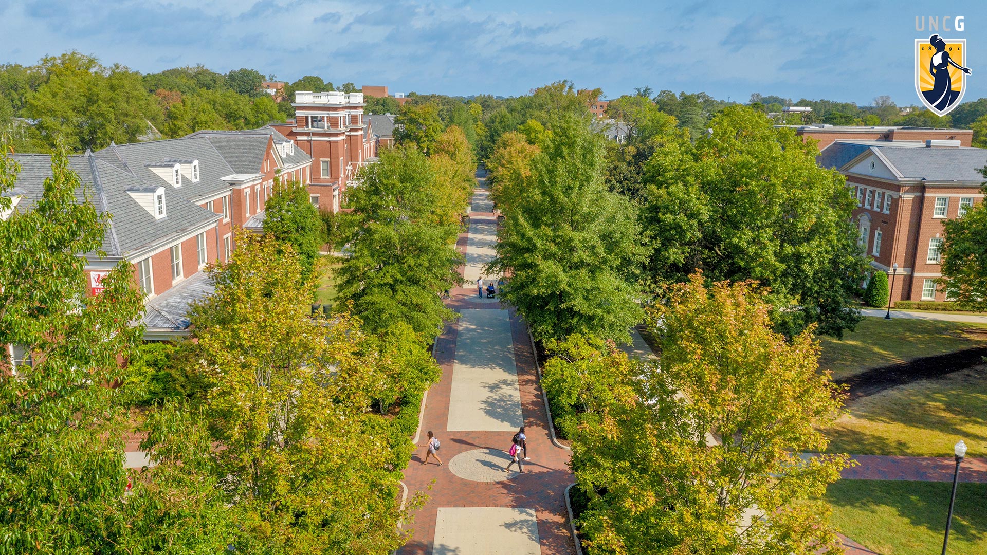 Aerial view of Collega Avenue with the UNCG logo in the top right corner