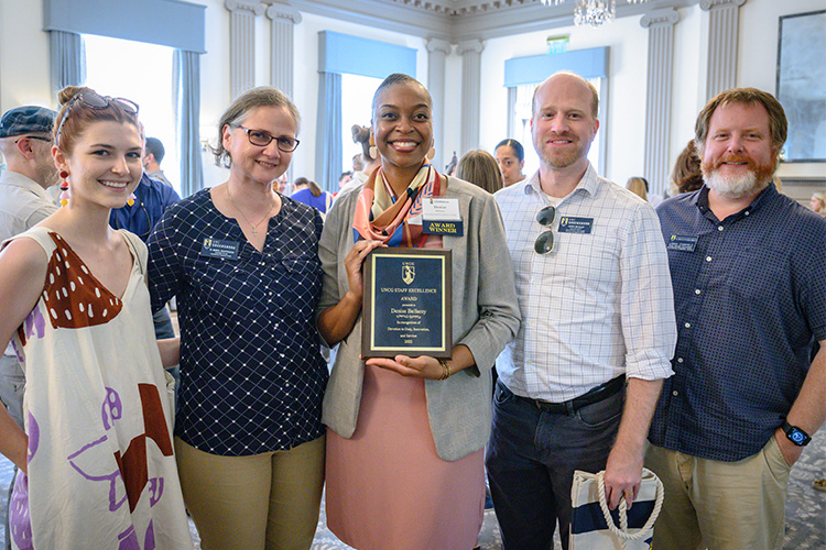 Staff members hold up award at appreciation event