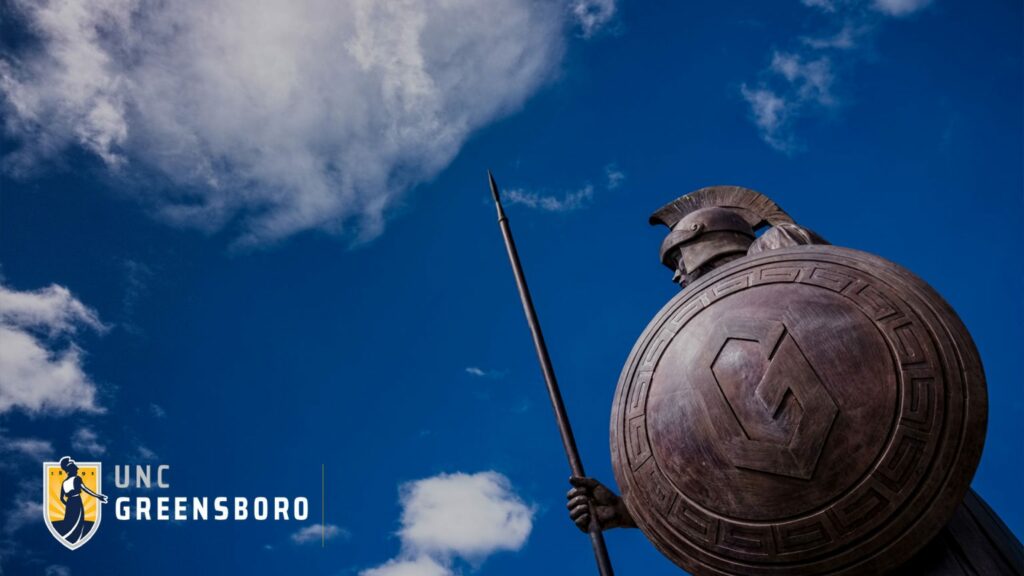 Wallpaper image of Spartan Statue against blue sky with clouds and UNCG logo in bottom left corner